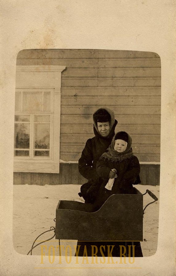 Неизвестная женщина с ребенком и коляской на полозьях